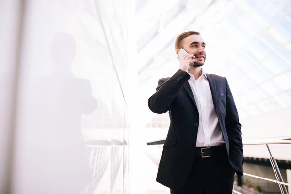 Affärsman talar på telefon och promenader runt kontoret — Stockfoto