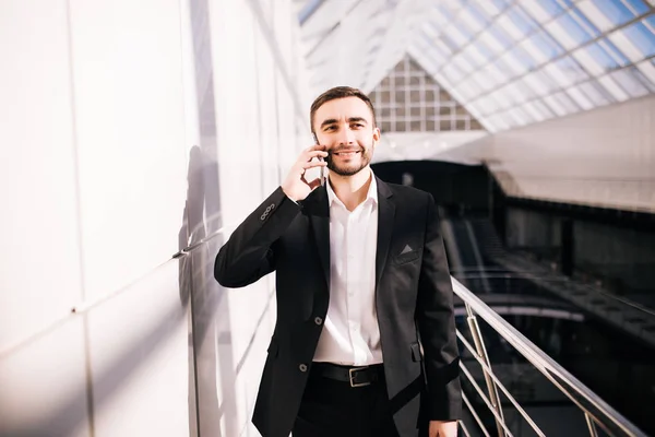 Affärsman talar på telefon och promenader runt kontoret — Stockfoto