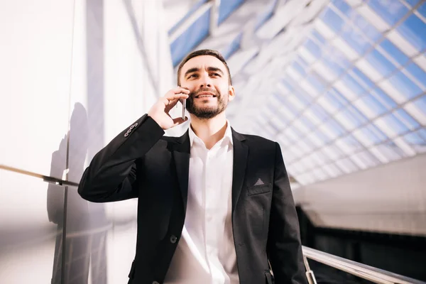 Podnikatel mluví o telefonu a procházky kolem úřadu — Stock fotografie