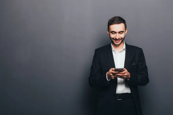 Junger Geschäftsmann im Anzug SMS am Telefon — Stockfoto