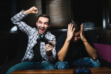 İki genç mutlu erkek video oyunları oynarken