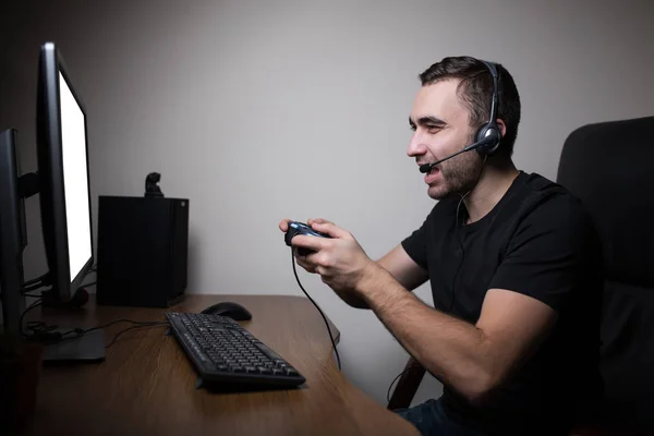 Νέος gamer ακουστικά και γυαλιά, χρησιμοποιώντας την κονσόλα και τον υπολογιστή για το παιχνίδι το παιχνίδι — Φωτογραφία Αρχείου