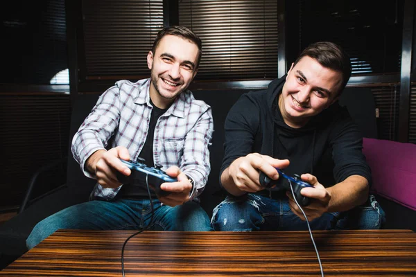 İki genç mutlu erkek video oyunları oynarken — Stok fotoğraf