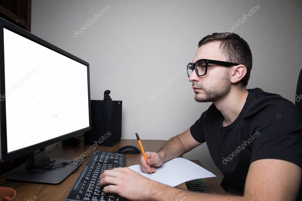 Man woking at PC on white screen monitor and make notice