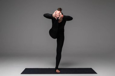 Santa şapka pratik yoga kadında güzel yoga gri arka plan üzerinde teşkil etmektedir.. 