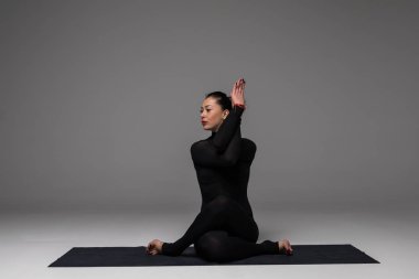 Santa şapka pratik yoga kadında güzel yoga gri arka plan üzerinde teşkil etmektedir.. 