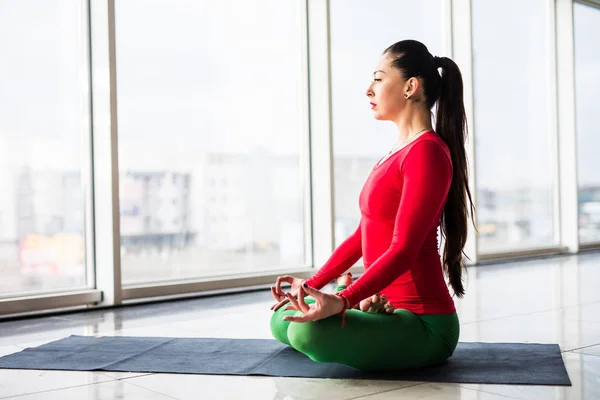 Vackra yoga kvinnan i santa hatt praktiken yogaställningarna på grå bakgrund. — Stockfoto