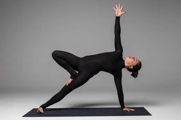 Bella yoga donna pratica yoga posa su sfondo grigio . — Foto Stock