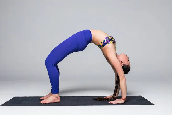 Wanita yoga yang indah berlatih pose yoga pada latar belakang abu-abu . — Stok Foto