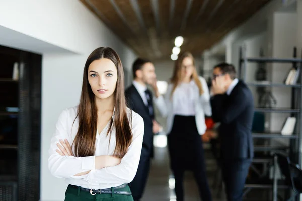 Młoda kobieta przed dyskusji współpracowników w nowoczesnym biurze. — Zdjęcie stockowe