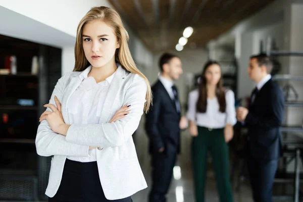 Biznes kobieta z jej personelem, grupy ludzi w tle w nowoczesnym jasnym biurze w pomieszczeniach — Zdjęcie stockowe