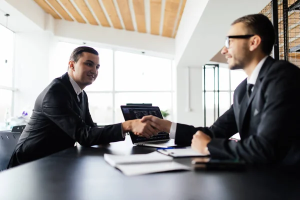 Vender concepto. Dos hombres se dan la mano y llegan a un acuerdo en su trato en la oficina . — Foto de Stock