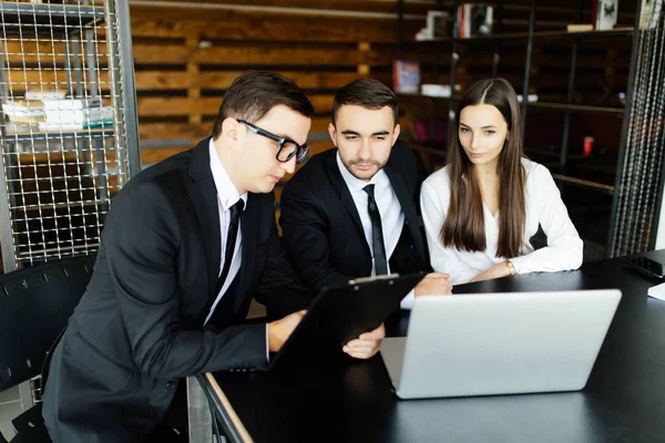 Kavram satmak. Genç adam bazı belge holding ve birlikte genç çift ofis masasında otururken işaret ve imza için sor.