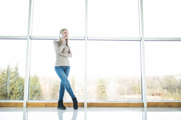 Όμορφο κορίτσι γραφείο μιλούν τηλέφωνο κατά μεγάλα παράθυρα με πανοραμική θέα — Φωτογραφία Αρχείου