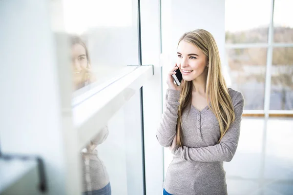 A fiatal üzleti nő portréja beszélni ellen panorámás windows telefon — Stock Fotó
