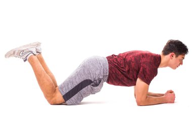 Diz plank. Genç adam spor egzersiz yaparak.