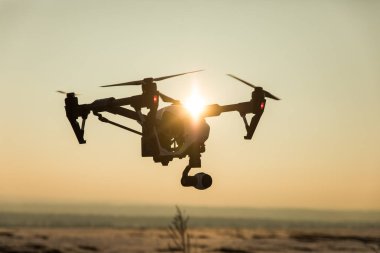 White drone with digital camera flying on sky background clipart