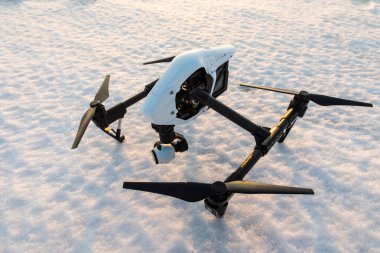 Beyaz drone ile kar üzerinde dijital fotoğraf makinesi duran