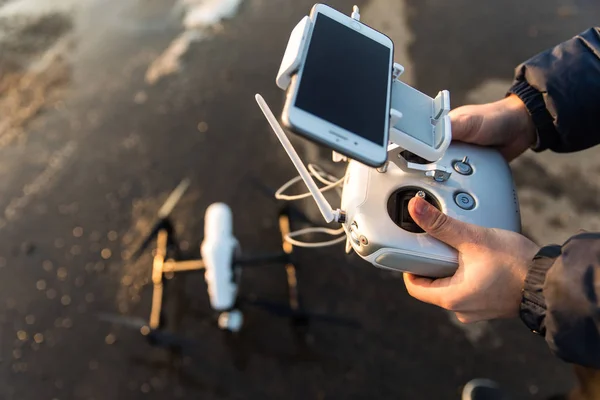 Człowiek z pilota zdalnego sterowania przygotować aparat cyfrowy biały drone dla lecą zimą — Zdjęcie stockowe
