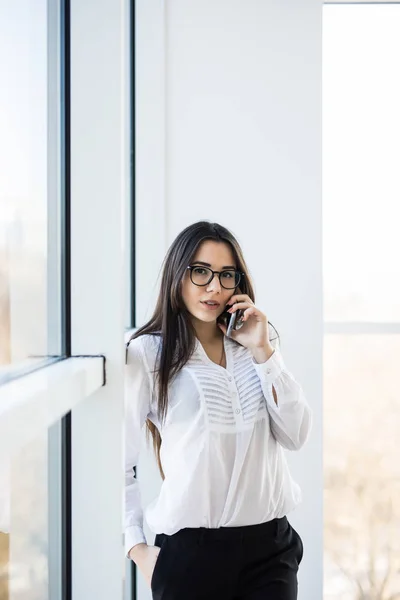 Business woman speak on phone near big office windows in modern smart space. — Stock Photo, Image