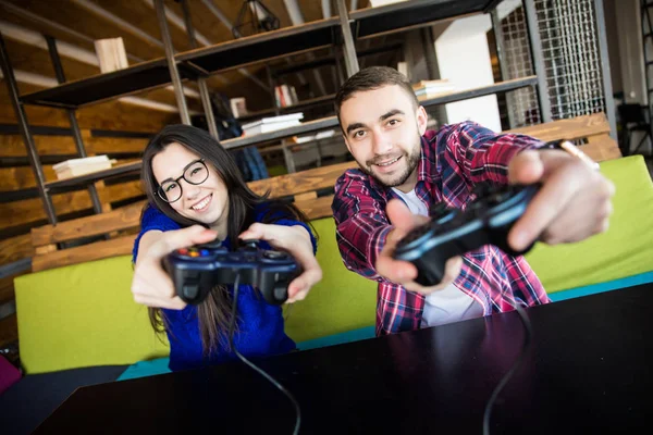 Jonge man en vrouw spelen videospelletjes. — Stockfoto