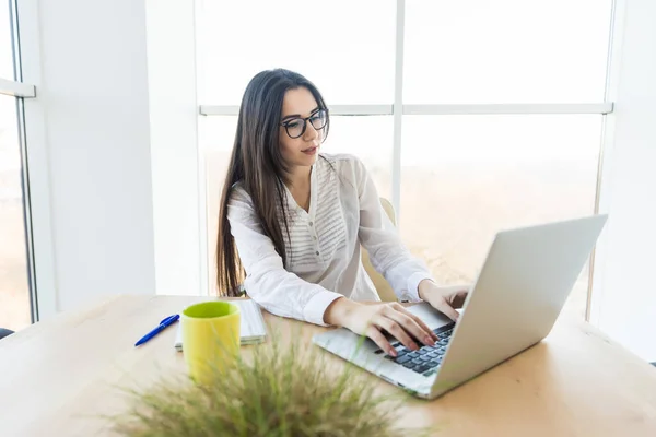 Mujer de negocios escribiendo en el ordenador portátil en su oficina . — Foto de Stock