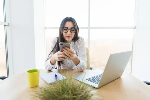 Dama de negocios hacer aviso desde el teléfono en su lugar de trabajo . — Foto de Stock