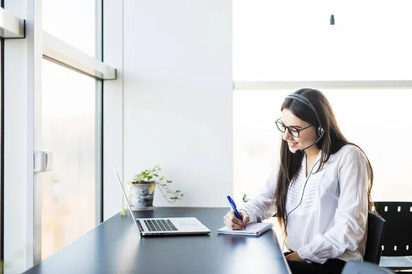 Çağrı merkezinde genç bayan iş ve kitapta dikkat edin