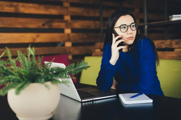 Ung dam talar på telefon på jobbet i moderna kontor. — Stockfoto