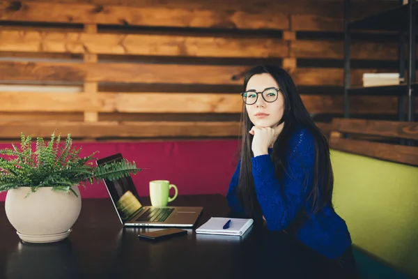 Giovane signora in ufficio moderno con computer portatile, pensando . — Foto Stock