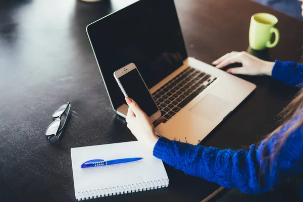 Close up of working lady at laptop and phone