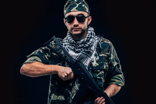 Terroristische atack. Portret van Terrorist met geweer en sunglases over de donkere achtergrond — Stockfoto