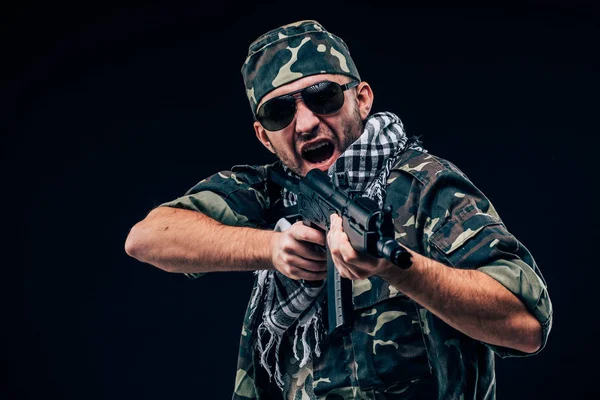 Terroristische atack. Portret van Terrorist met geweer en sunglases over de donkere achtergrond — Stockfoto