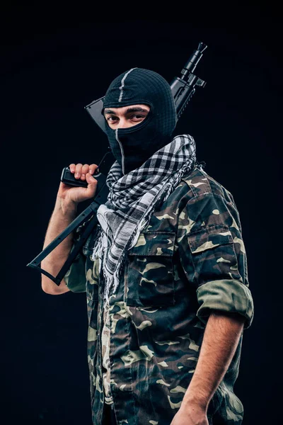 Terroristische aanslag. Terrorist met pistool op zwarte achtergrond — Stockfoto