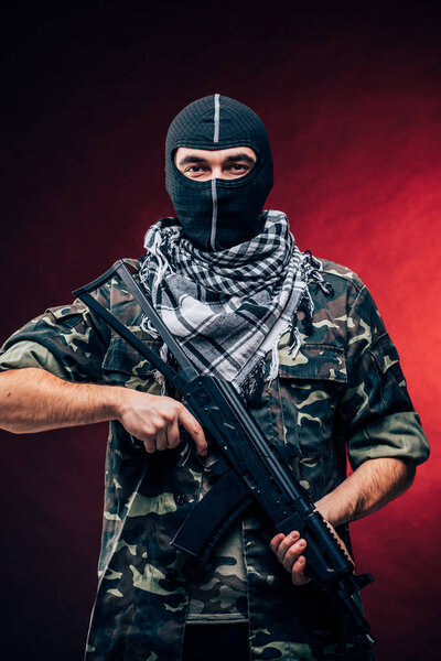 Террористический акт. Террорист с пистолетом на черном фоне
