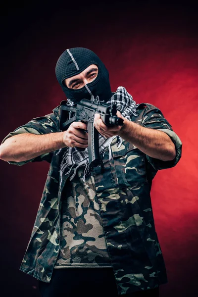 Terroristische aanslag. Terrorist met pistool op zwarte achtergrond — Stockfoto