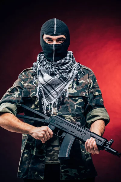 Terroristische aanslag. Terrorist met pistool op zwarte achtergrond — Stockfoto