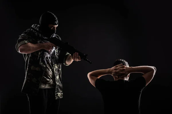 Terrorista fegyvert a túszt a fekete háttér — Stock Fotó