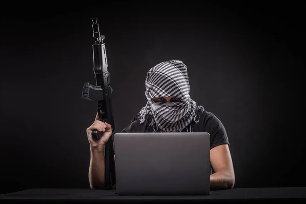 黑客用枪在黑色背景上的笔记本电脑 — 图库照片