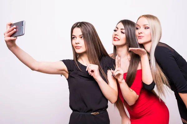 Três modelos em vestidos da noite fazem a selfie no branco — Fotografia de Stock
