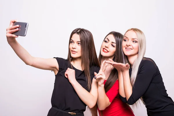 Três modelos em vestidos da noite fazem a selfie no branco — Fotografia de Stock