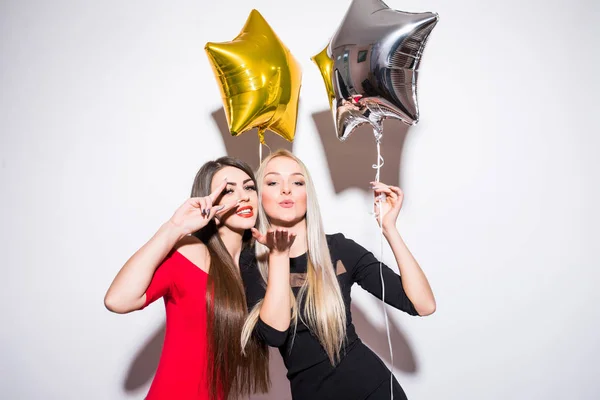 Dwa uśmiechający się ładny młodych kobiet z balonów z okazji i pozowanie na kamery. — Zdjęcie stockowe
