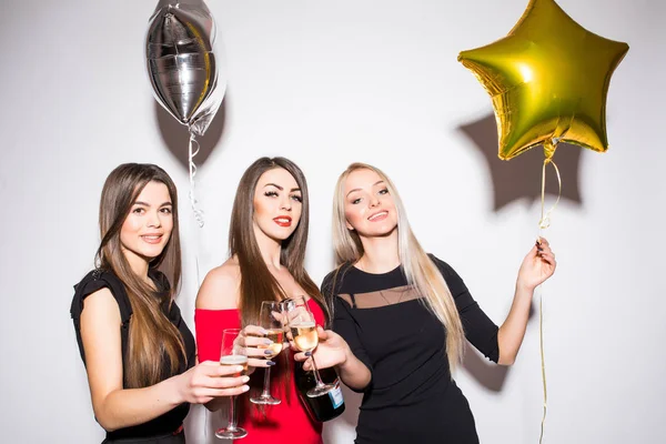 Trzy młode kobiety obchodzi i pić szampana dla strony — Zdjęcie stockowe