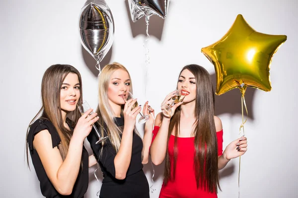 Wesoły młodych kobiet picie szampana, rozmawiając i śmiejąc się z balonów na party — Zdjęcie stockowe