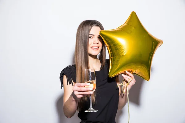 Feliz joven atractiva en vestido negro sosteniendo globo en forma de estrella y beber champán — Foto de Stock