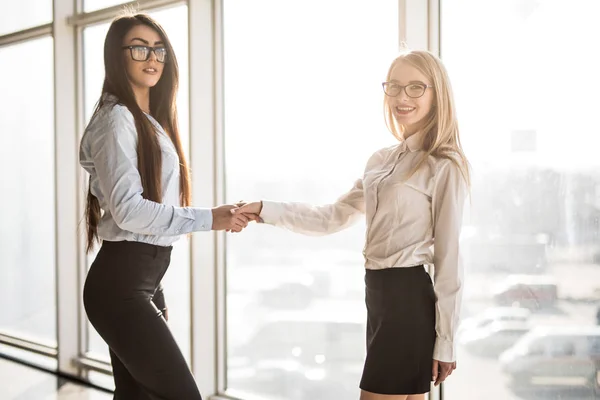 Joven mujer de negocios apretón de manos por ventana panorámica . —  Fotos de Stock