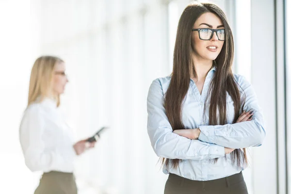 Retrato de mujer de negocios joven en la sala de oficina sobre fondo de colega de trabajo . — Foto de Stock