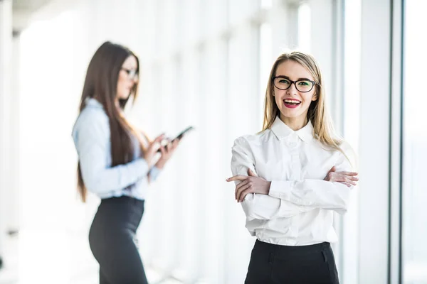 Retrato de mujer de negocios joven en la sala de oficina sobre fondo de colega de trabajo . — Foto de Stock