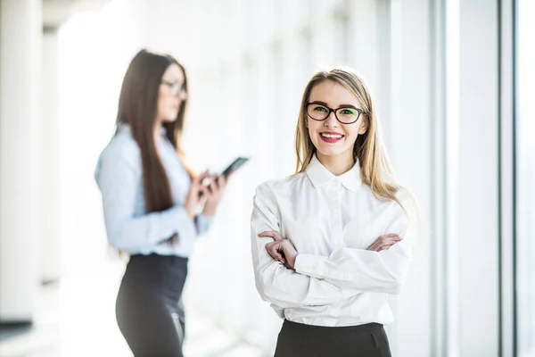 Retrato de mujer de negocios joven en la sala de oficina sobre fondo de colega de trabajo . — Foto de Stock