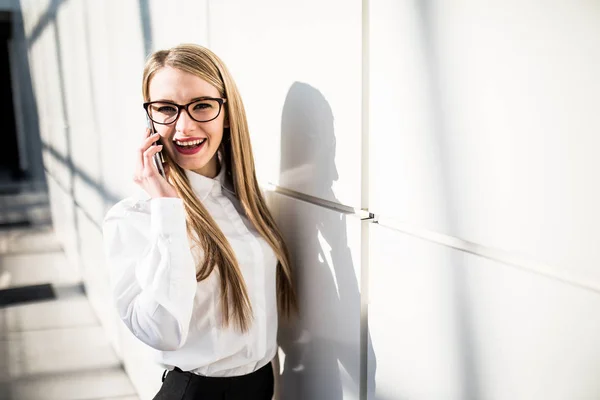 Giovane donna con cellulare in ufficio — Foto Stock